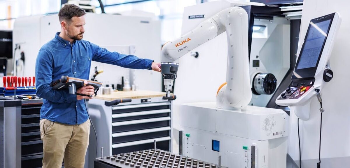 Operator programmeert KUKA cobot met teach pendant in industriële productieomgeving